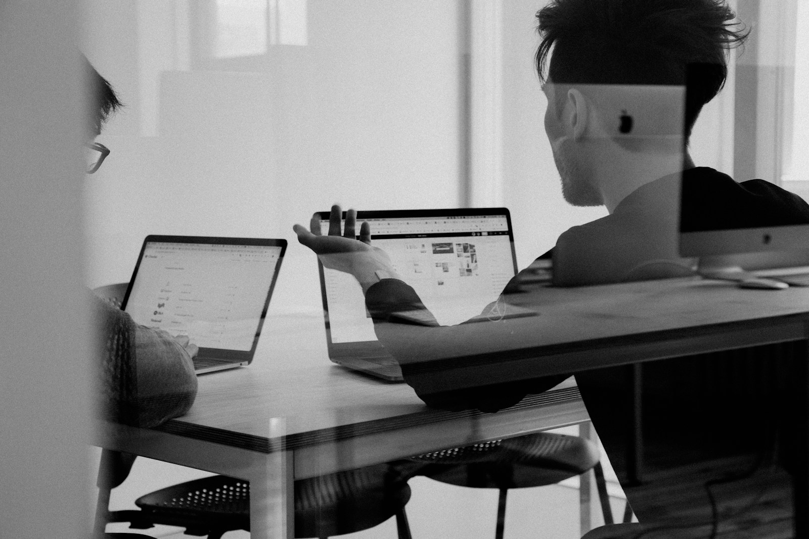 Two colleagues discussing work at a desk
